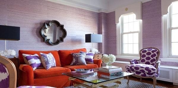 Purple throw pillows on an orange sofa