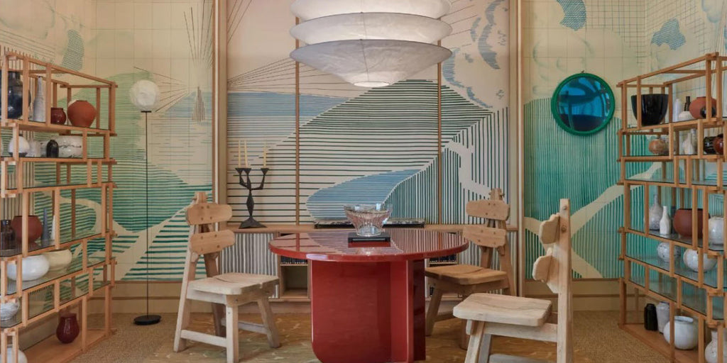 breakfast room, dining room, Waldo Works, memphis design, abstract wallpaper, abstract mural wallpaper, blue and green design, abstract geometric wallpaper, round dining table, red table, wooden dining chairs, tan area rug, wooden bookshelves