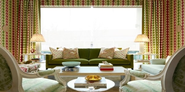 red and green living room featuring Brunschwig cevennes fabrics, traditional design, red and green design, green upholstered velvet sofa, wood coffee table, green upholstered chairs, matching wallpaper and fabric, patterned lamp shades, throw pillows