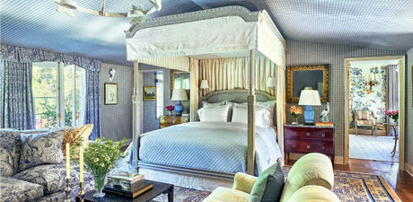 blue bedroom with canopy bed, traditional, french inspired bedroom, michael smith designed bedroom, tented ceiling, upholstered walls, traditional area rug, four poster bed, canopy bed, light green upholstered chairs, floral upholstered sofa, mirror