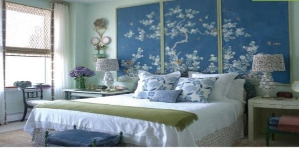 Blue and white bedroom by celerie kemble, blue and white design, blue screen accent wall, blue and white pillows, white table lamp, white sheer drapery, green throw blanket, blue bench, wood accent chair, tan area rug, blue and white design