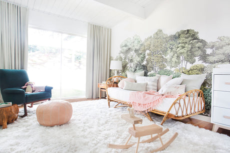 Emily henderosn designed nursery with a charming woodland scene and rattan daybed.