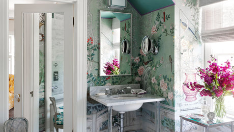 Green powder room with floral bird wallpaper, marble sink, chrome fixtures, and colorful ceiling
