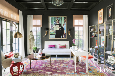 dramatic home office with dark walls, a white desk and white sofa, and purple arearug
