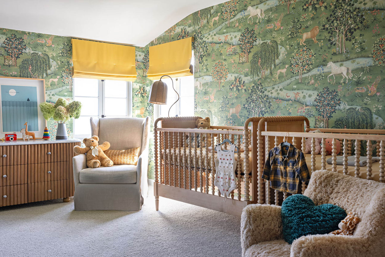 a nursery with green menagerie wallpaper filled with charming animals and unicorns.