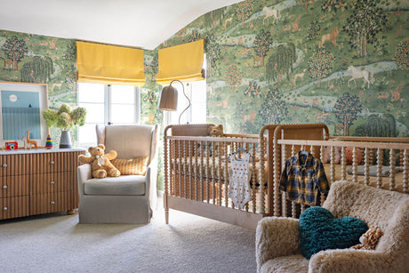 a nursery with green menagerie wallpaper filled with charming animals and unicorns.