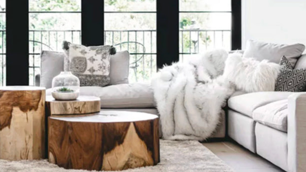 Cozy family room with white sofa and natural wood coffee tables by large windows; Phillips teak coffee table, DV Kap white faux fur throw