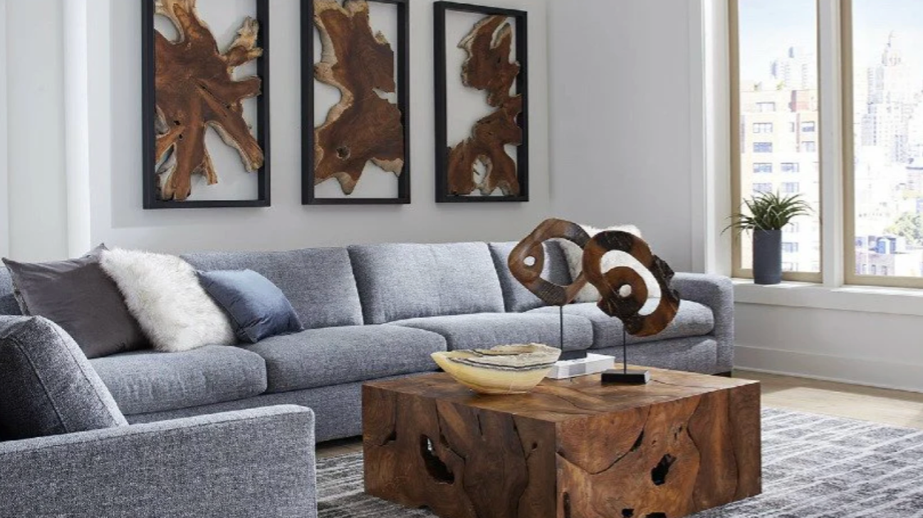 Modern family room with blue gray sectional sofa, natural wood coffee table, and abstract wood wall art in a bright contemporary space