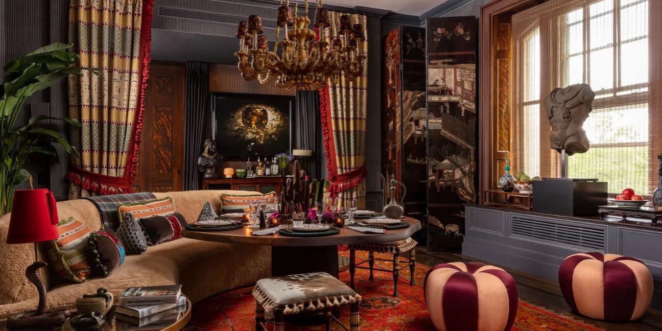 curved sofa, exotic, boho dining room, moody, dark dining room, kips bay new york 2023 showhouse, wood panel dining room, traditional design,  dark tone design, brown and orange throw pillows, gold chandelier lighting, round dining table, bench seat