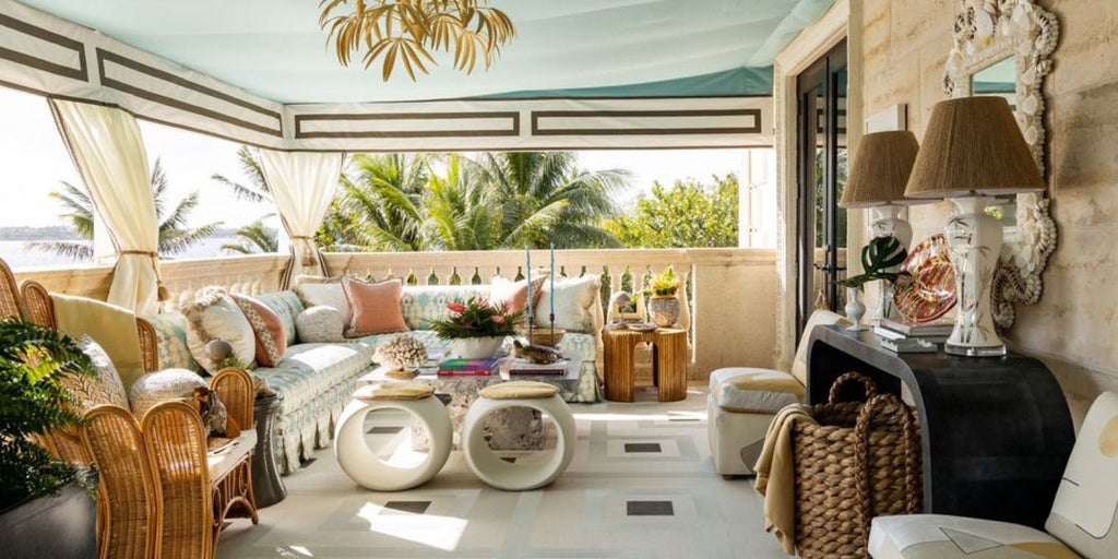 Palm Beach Kips Bay SHowhouse, honey collins, terrace design, rattan furniture, outdoor l iving, white circular stools, glass outdoor coffee table, geometric outdoor area rug, blue tented ceiling, white table lamps, gold pendant lighting, l couch