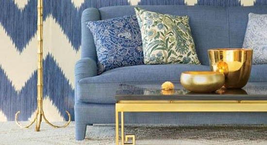 blue sofa, blue couch, coffee table, metal coffee table, gold coffee table, glass top coffee table, gold accent decor, green and blue throw pillows, blue and white chevron wallpaper, grey area rug, blue and gold living room