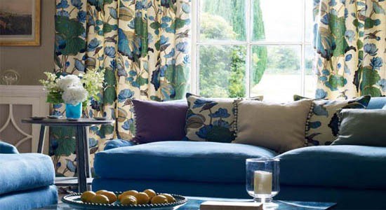 G P & J Baker fabric blue sofa with floral throw pillows and peacock print drapes