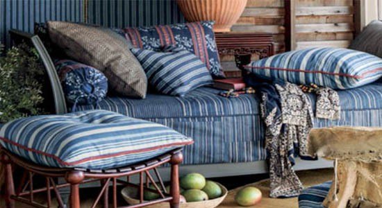 Lounging area with a chair and throw pillows upholstered using Ralph Lauren fabrics