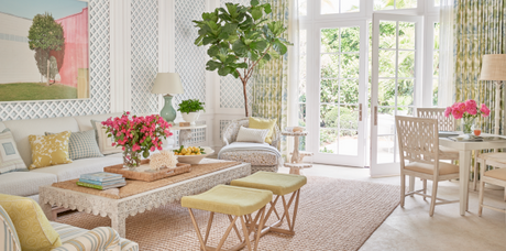 lattice walls, colorful living room, throw pillows, area rug, curtains, floral drapery, tan area rug, textured rug, white coffee table, pastel wall art, pastel design, green drapery, yellow throw pillow, yellow accents, pastel design, blue lamp