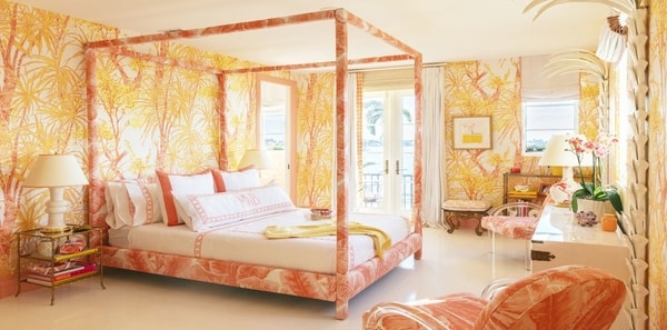 Yellow floral bedroom by Meg Braff for Kips Bay Showhouse Palm Beach 2019, yellow tropical wallpaper, sunny tropical design, orange and yellow design, upholstered bed frame, orange accent chair, white vanity table, gold bedside table, white draperies