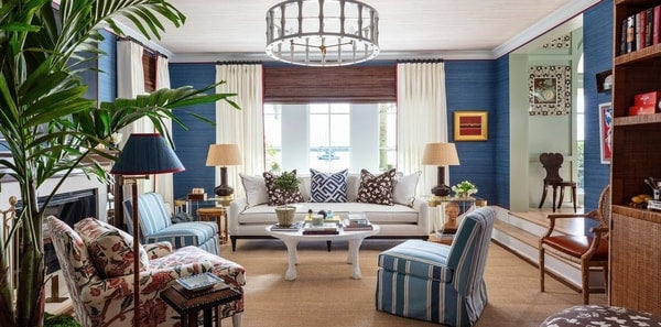 Blue living room, kips bay palm beach 2021, blue silk wallpaper, floral fabric, benjamin deaton, floral upholstered chair, blue striped upholstered fabric, blue grasscloth wallpaper, blue floor lamp, brown and blue throw pillows, round pendant light