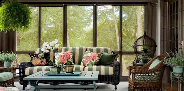 Rustic porch, outdoor fabric, green and beige striped fabric, rattan chair, outdoor living space, outdoor upholstery fabric, striped couch, green and white design, earth tones, beige area rug, blue coffee table, blue serving tray, blue vase