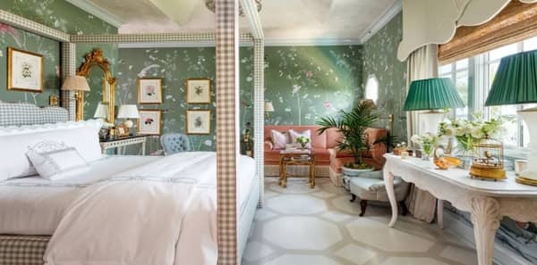 kips bay palm beach, green floral wallpaper, green bedroom, kips bay palm beach 2022, brittany bromly, floral wallpaper, elegant florals, green and white fabric, plaid upholstered bedframe, geometric area rug, white table lamps, four poster bed