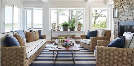 modern coastal, coastal living room, rattan chairs, rattan sofa, liz caan, modern coastal with rattan furniture, coastal living room with striped area rug, liz caan coastal living room, coastal design with wicker decor, blue white and tan pillows