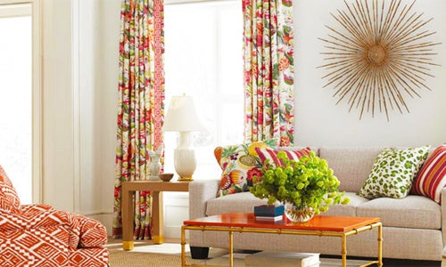 Brunschwig & Fils Fabric  light colored sofa with stripe and floral throw pillows, floral drapes and ikat accent chair 