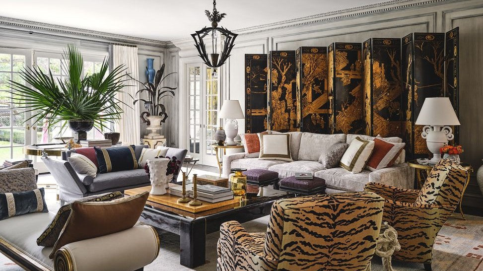living room with tiger upholstered chairs, chinese black and gold screen, kips bay dallas showhouse, michael aiduss, animal print fabric, tiger upholstered chair, black coffee table, pendant lighting, throw pillows, chaise lounge, white table lamps