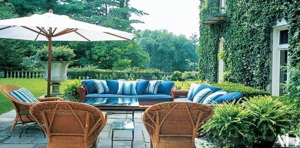Ralph Lauren blue striped outdoor fabric, outdoor living space, outdoor upholstery fabric, rattan chairs, glass outdoor coffee table, glass side table, white patio umbrella, blue upholstered sofa, blue and white striped throw pillows, stone planter