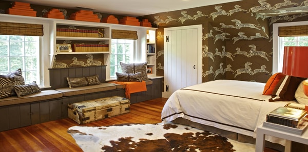 scalamandre zebras wallpaper, safari design, zebra wallpaper, earth tones, earth tone design, animal inspired design, zebra wallpaper, scalamandre, iconic zebra wallpaper, animal area rug, hide rug, orange and brown design, orange throw pillow