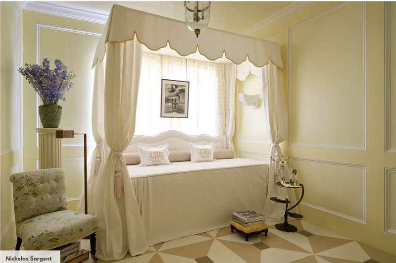 Traditional bedroom with yellow walls, canopy daybed, soft drapery, classic molding, and elegant vintage-inspired décor