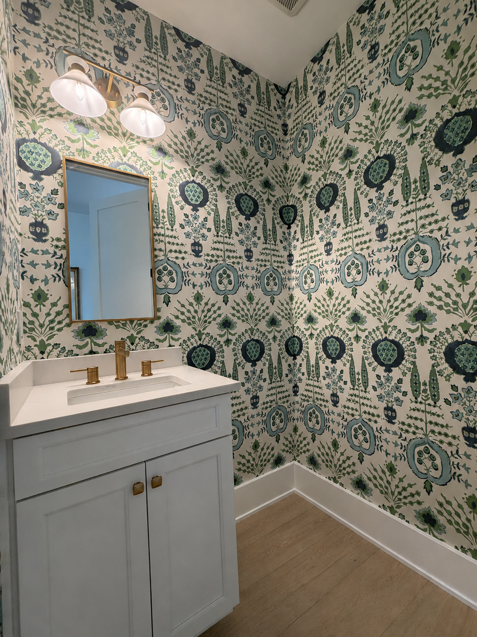 Bathroom with patterned wallpaper, sink, and mirror.